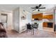 Cozy living room features a dining area with black table and chairs, complemented by the kitchen with warm wood cabinets at 1216 S Uvalda St, Aurora, CO 80012