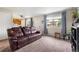 Inviting living room with plush seating, neutral walls, and views through the bright window at 1216 S Uvalda St, Aurora, CO 80012