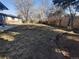 Large backyard with wood fence and sparse grass under mature trees at 3762 S Fenton Way, Denver, CO 80235