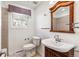 Bathroom featuring wood vanity, decorative mirror and window providing natural light at 3762 S Fenton Way, Denver, CO 80235