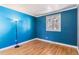 Bright bedroom featuring blue accent wall, hardwood floors, and a window providing natural light at 3762 S Fenton Way, Denver, CO 80235