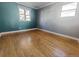 Bedroom featuring two-tone gray and teal paint, hardwood floors, and bright windows at 3762 S Fenton Way, Denver, CO 80235