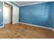 Bedroom features blue wall, hardwood floors, closet, and bright natural light at 3762 S Fenton Way, Denver, CO 80235