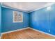 Bedroom with hardwood floors, blue walls and single window at 3762 S Fenton Way, Denver, CO 80235