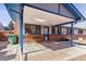 Covered brick patio with skylights, blue trim, and two metal chairs at 3762 S Fenton Way, Denver, CO 80235