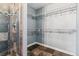 Shower and walk in closet featuring stone look tile and wire rack shelving at 3762 S Fenton Way, Denver, CO 80235