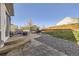 Backyard with a stone patio, furniture, grill, trampoline, grass area, and a wooden fence at 9990 Jasper St, Commerce City, CO 80022
