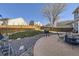 Backyard with a stone patio, furniture, grill, grass area, a large tree, and a wooden fence at 9990 Jasper St, Commerce City, CO 80022