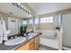 Well-lit bathroom featuring double sinks, a bathtub, a glass door shower, and stylish light fixtures at 9990 Jasper St, Commerce City, CO 80022
