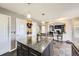 Bright kitchen featuring a granite island with pendant lights, wood accents, and seating for entertaining at 9990 Jasper St, Commerce City, CO 80022