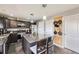 Modern kitchen with dark cabinets, stainless steel appliances, granite island with seating, and wood-accent wall at 9990 Jasper St, Commerce City, CO 80022