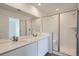 Modern bathroom with double sinks, white cabinets, and a glass-enclosed shower at 15277 Fillmore St, Thornton, CO 80602