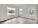 Sunlit bedroom with hardwood floors and three windows offering neighborhood views at 15277 Fillmore St, Thornton, CO 80602