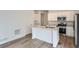 Modern kitchen featuring an island, stainless steel appliances, and hardwood flooring at 15277 Fillmore St, Thornton, CO 80602