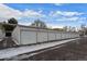Exterior view of white garages in a row with snow in front and above on a bright day at 9300 E Center Ave # 2B, Denver, CO 80247