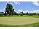 Scenic golf course with pond and trees in the distance, showcasing the well-manicured green at 9300 E Center Ave # 2B, Denver, CO 80247