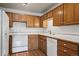Well-maintained kitchen featuring bright white appliances and plenty of wood cabinets at 9300 E Center Ave # 2B, Denver, CO 80247