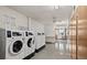 Spacious communal laundry room with multiple machines and folding area at 9300 E Center Ave # 2B, Denver, CO 80247