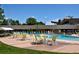 A community pool with tables and lounge chairs sitting on the pool deck on a sunny day at 9300 E Center Ave # 2B, Denver, CO 80247