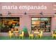 Exterior of Maria Empanada restaurant with outdoor seating and yellow chairs at 1188 S Sherman St, Denver, CO 80210