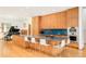 A modern kitchen with a gas cooktop island, wooden cabinets, hardwood floors, and stainless steel appliances at 1188 S Sherman St, Denver, CO 80210