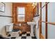 Charming bathroom with brick accent wall, pedestal sink, and checkered floor at 3777 Newton St, Denver, CO 80211