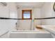 Bright white bathroom featuring a tub and shower combination under a window at 3777 Newton St, Denver, CO 80211