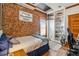 Cozy bedroom features a brick wall, a built-in bookcase, and a window at 3777 Newton St, Denver, CO 80211