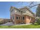 Exterior view of the brick house with a green backyard and steps to patio at 3777 Newton St, Denver, CO 80211