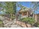 Quaint brick home with a fenced yard, mature trees, and charming front porch at 3777 Newton St, Denver, CO 80211