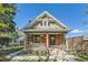 Charming brick home with a welcoming front porch, columns, and beautiful landscaping at 3777 Newton St, Denver, CO 80211