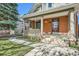 Inviting front porch with a swing, classic columns, and flowering plants at 3777 Newton St, Denver, CO 80211