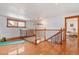 Bright upstairs hallway features hardwood floors, striking banister, and plenty of light at 3777 Newton St, Denver, CO 80211