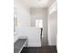 Bright hallway with white walls, modern art, large window, and tile flooring leading to stairs at 1932 W 32Nd Ave, Denver, CO 80211