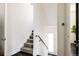 Bright staircase featuring a carpeted runner and a sleek, modern handrail leading to the upper level at 1932 W 32Nd Ave, Denver, CO 80211