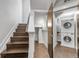 View of the staircase with adjacent laundry room featuring stacked washer and dryer units at 1932 W 32Nd Ave, Denver, CO 80211