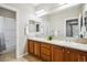 Bright bathroom with double sinks, granite counters, a large mirror and an adjacent shower at 2601 Pemberly Ave, Highlands Ranch, CO 80126