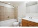 A basic bathroom with a tub, shower, and vanity, tiled and painted in neutral tones at 2601 Pemberly Ave, Highlands Ranch, CO 80126
