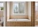 A luxurious soaking tub is nestled beneath a decorative window in this bathroom at 2601 Pemberly Ave, Highlands Ranch, CO 80126