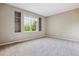 A carpeted bedroom showcasing built-in shelves flanking a window that offers a green view at 2601 Pemberly Ave, Highlands Ranch, CO 80126