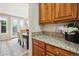 Granite counter tops with wood cabinets leading to dining room with modern chandelier at 2601 Pemberly Ave, Highlands Ranch, CO 80126