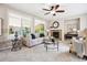 Bright and inviting living room with a fireplace, neutral color scheme, large windows, and a ceiling fan, creating a cozy space at 2601 Pemberly Ave, Highlands Ranch, CO 80126