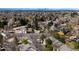 Aerial view of a neighborhood showcasing mature trees and Denver city skyline in the distance at 4027 E Geddes Cir, Centennial, CO 80122