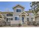 Inviting townhome with large windows, a covered porch, and a seating bench for relaxing outdoors at 4027 E Geddes Cir, Centennial, CO 80122