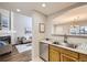 Inviting kitchen with stainless steel appliances, wood cabinets and seamless flow to the living room and dining area at 4027 E Geddes Cir, Centennial, CO 80122