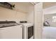 Bright laundry room with modern washer and dryer units and convenient shelving at 4027 E Geddes Cir, Centennial, CO 80122