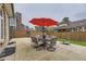 Spacious backyard with patio, outdoor seating under a bright red umbrella, and lawn area at 5426 S Jasper Way, Centennial, CO 80015
