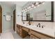 Bathroom with double sinks, wood cabinets, and a vanity mirror with decorative lighting at 5426 S Jasper Way, Centennial, CO 80015