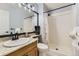 Bright bathroom with a shower, white tile, and a granite countertop sink at 5426 S Jasper Way, Centennial, CO 80015