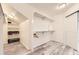 Bright walk-in closet with custom storage solutions and a gray wood floor at 5426 S Jasper Way, Centennial, CO 80015